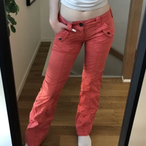 Byxor - Säljer de här lågmidjade, coola, orange/röda ”cargo” byxorna från secondhand. Jättebra skick då jag använt de bara en gång, säljer just därför. 