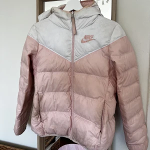 Nike jacka - Fin jacka från Nike men lite smutsig (går att tvätta, har inte provat). Går att vända in och ut för att ha den helrosa. Skriv för fler bilder.