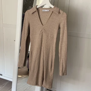 Beige klänning med krage - Superfin beige klänning från Bershka sommaren 2022, storlek S, aldrig använd! Ny pris 379kr 