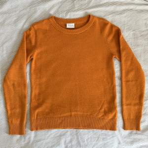 En snygg orange stickad tröja i S. 