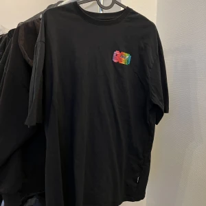 Svart t-shirt oversize - Svart oversize t-shirt med ett litet tryck på bröstet. Väldigt långa ärmar. Har blivit använd ett par gånger men i bra skick. 