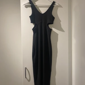 Svart lång klänning  - Storlek: XS  Från H&M Tajt lång svart klänning med snygg utskärning i midjan!  Aldrig använd. 