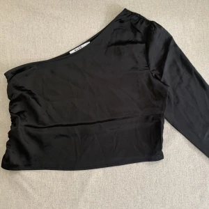 one shoulder blus  - En svart oneshoulder blus/topp i satin! Storlek 40 från NA-KD