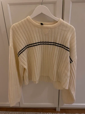 Långärmad tröja - Långärmad tröja i något kortare modell, men inte croppad. Cremeviy färg med svart detalj.