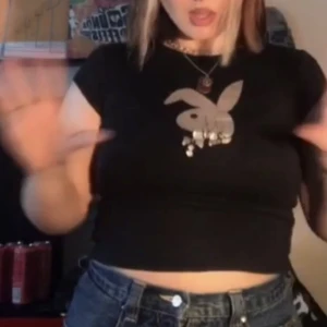Playboy babytee - En svart babytee med ett glittrigt playbunny märke! Superfin men kaninen har flagnat lite längst ner💓 funkar bra på xs/s men även m/l!💗💖💘