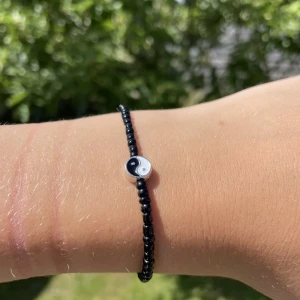 Pärlarmband  - Ett svart pärlarmband med ett yin och yang täcken i storlek s men finns också i fler storlekar om man vill ha, kontakta oss om de finns frågor!💗💕