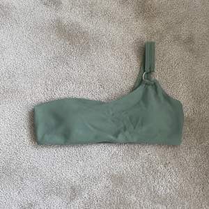 Snygg grön bikini överdel med metall ring på vänster sida. Lätt att matcha med bikini underdelar! (Endast testad) Använd gärna köp nu!