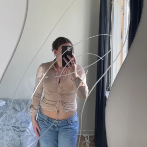 Tröja  - Långärmad beige topp. Lite gnistrande. Rynkad med knappar. Knappt använd!