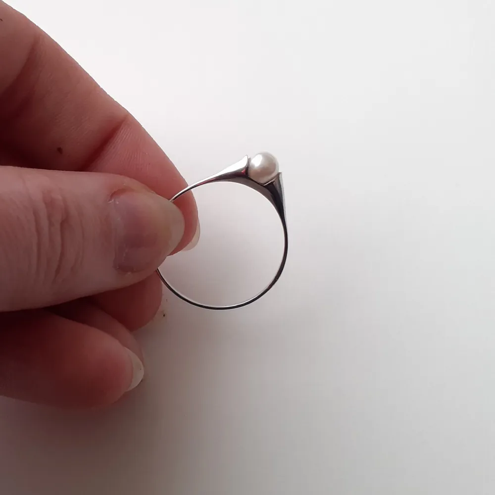 Ring i äkta silver med vit pärla. Helt oanvänd och i nyskick. Storlek 65 (2 cm i diameter) Frakt: 15 kr Ask: 10 kr (valfritt). Asusteet.