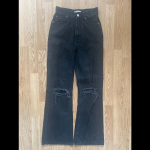 håliga wide jeans - svarta wide jeans med hål vid knäna från bershka. rätt så använda men i bra skick. säljes då dom ej passar mig längre. skönt och lite stretchigt jeansmaterial. nypris 359kr