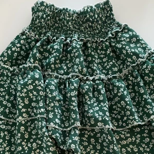 Grön/blommig kjol - veckad grön kjol, blommig, använd endast 1 gång 💕🌿