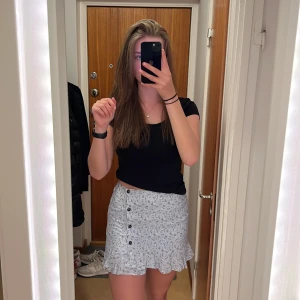 Blommig kjol från Hollister - Jättefin ljusblå kjol från Hollister💙 På kjolen finns små vita blommor, i sidan finns knappar och längst ner finns en söt liten volang💃 Inte särskilt använd🙏