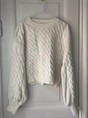 Kabelstickad tröja  - lite croppad vit stickadtröja 