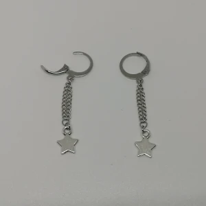 Örhängen ~stjärna med kedjor~ - Örhängen gjorda/designade av mig. Nya/oanvända. Huggies/ringar i 304 rostfritt stål. (frakt: 15 kr för frimärke) 