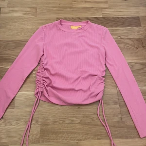Rosa tröja  - Rosa tröja med snörningar på bägge sidor!  