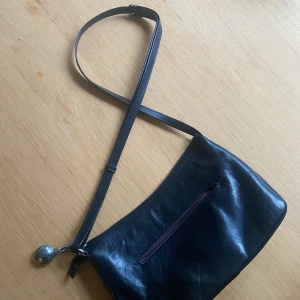 Väska - Praktisk svart axelremsväska i skinn i bra kvalité och storlek med flera fack! 