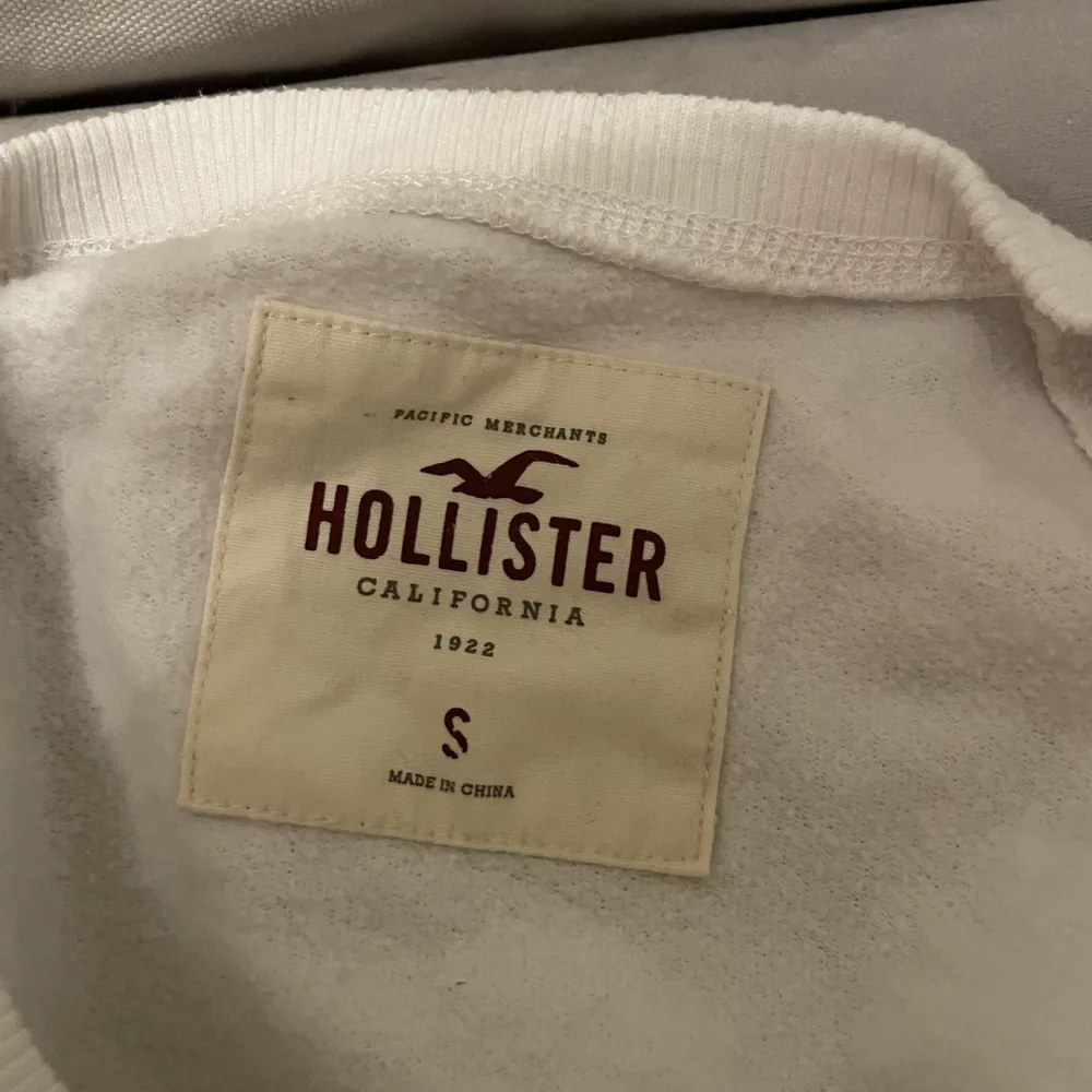 Vit sweatshirt från hollister med inbroderad text. 