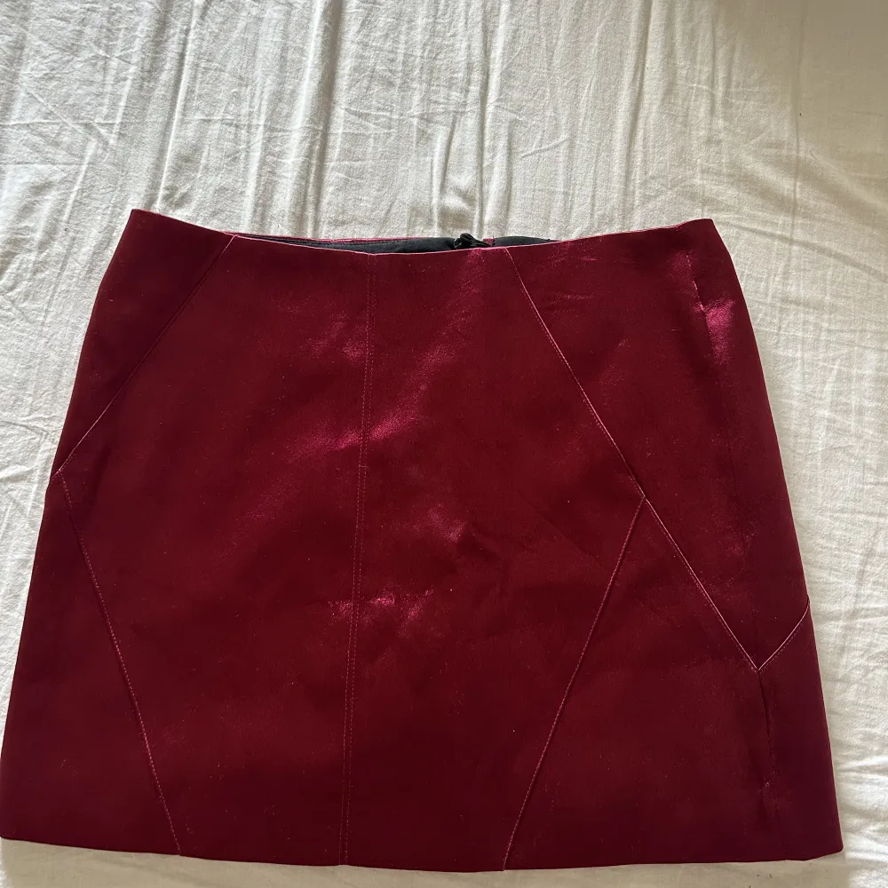 Vinröd kort kjol från h&m endast använd en gång, dragkedja på sidan. Kjolar.