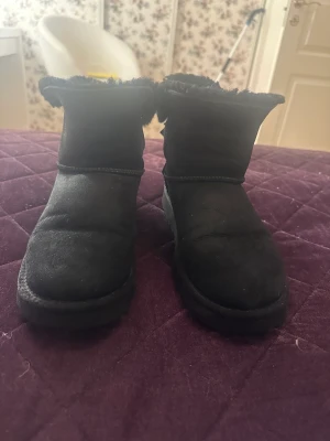 Ugg  - Svarta uggs med rosett i storlek 37, använda en vinter. Köpta för 2500.