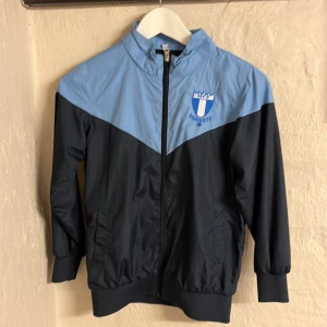 MFF regnjacka  - En blå mff jacka utan luva. Hyfsat skick, har knappt använt den.