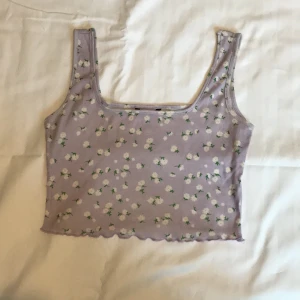 Lila linne med blommor  - - Plagg: Kroppat linne  - Mönster: Blommigt  - Färg: Lila  - Storlek: M  - Märke: Shein - Skick: Väldigt bra  - Egenskaper: Ribbad, Stretchig, ganska kort, salladskant på botten  Kontakta mig gärna vid frågor 💕