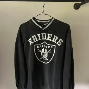 En svart tröja med trycket ”Raiders” på. Vilket jag tror är ett lag i amerikansk fotboll 🏈. Den är köpt på hm. Storlek xs. Och den är i väldigt fint skick! 🤩