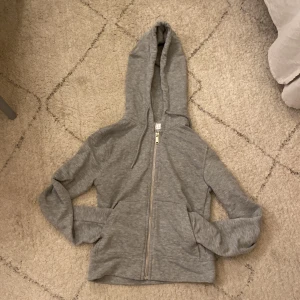 Grå hoddie - En grå hoddie köpt från h&m för 200kr säljer för 120kr. Storlek Xs, bra material o lite croppt. Aldrig använt.