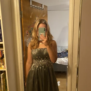 Nyårsklänning - Säljer denna perfekta nyårskläningen. Den är knappt andvänd och i fint skick nån av stenarna är lite lös men lätt att lösa. Klänningen är i storlek S men skulle mer säga att den är som en M