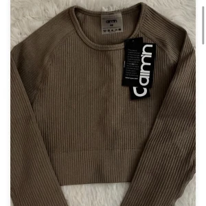 Träningströja från Aim’n  - Långärmad ribbad träningströja från Aim’n. Helt oanvänd. Storlek xs. Beige/brun färg 