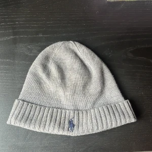 Polo Ralph Lauren mössa - En grå polo Ralph Lauren mössa som jag köpte på zalando för 699:-. Jag säljer då den inte kommer till användning! Skick 8/10