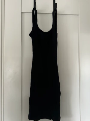 Klänning - Svart klänning i ribbat material. Endast använd en gång.
