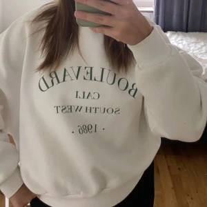 Sweatshirt från Nelly - Vit sweatshirt med grönt tryck från Nelly! Nästan aldrig använd🩷100kr+frakt!