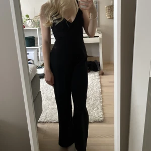 Fin jumpsuit - Festlig svart jumpsuit med snygga detaljer på axelbanden! Använd 1-2 gånger så i nyskick. Passar mig som är 164 xs bra