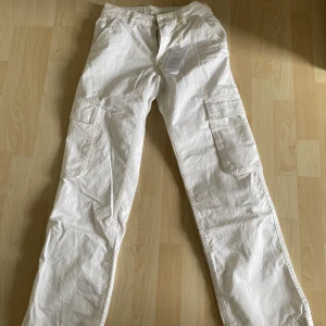 Vita cargobyxor  - Helt nya, oanvända cargobyxor. Byxorna är från Gina och är helt slutsålda på sidan. Storlek 32. Säljer byxorna pga för små. 