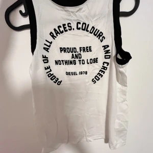 Ärmlös topp / sleeveless top  - Gott skick. Snyggt material för sommaren, inte för tjockt. Vit, svart skrift och konturer. Äkta diesel. /Good condition. Nice material for summer, not too thick. White, black writing and outlines. Authentic diesel. 