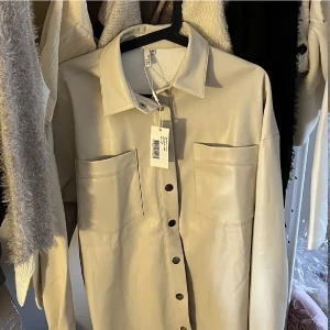 Skinn skjorta  - Beige skinn skjorta som kan användas som skjortjacka! Strl 36 (stor i storleken) & PRISLAPP kvar 🤍 nypris är runt 500 kr & jag säljer för 50 kr❣️ från Nelly⚡️ använd gärna köp nu!🤝