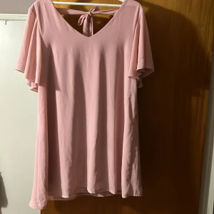 Klänning  - Rosa klänning med rosett, i stortsätt oanvänd