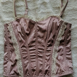 Ljusrosa Korset  - Justerbara band. Går att öppna på sidan med hakar. Knytning i ryggen. Är stålpinnar inne i den vilket gör den stabil