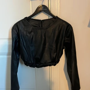 Svart långärmad tröja  - Svart croppad tröja i fake läder. Använd en gång