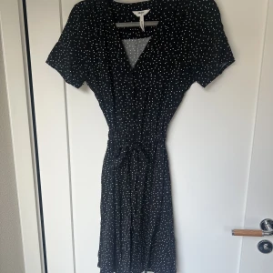 Sommarklänning!  - Jättesöt prickig klänning i tunt material med knappar hela vägen ned. Midjeband finns också! Superbra skick! 