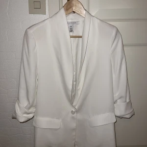 Kavaj  - Vit kavaj från Nelly. Storlek 34/XS. Korta ärmar.