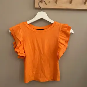 Orange croppad tröja från Zara med volang på sidan. Inga defekter, sparsamt använd