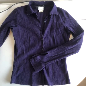 Lila figursydd skjorta  - Lila skjorta XS Behaglig mörklila färg. Skjortan är figursydd i veckat tyg. Supersnygg men är tyvärr för liten för mig 💜Fint skick hittad second hand. 
