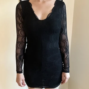 Svart spetsklänning  - Svart spetsklänning med semiöppen rygg från Nelly, storlek S. 