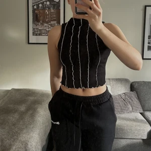 Topp - Svart topp med vita sömmar, använd men i fint skick