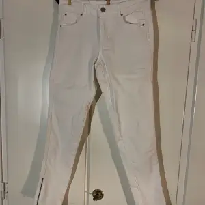 Vita jeans med dragkedja längst ner vid anklarna