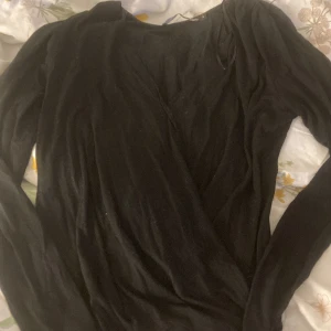 Svart v-ringad tröja - Svart v-ringad tröja, lös vid magen tajt vid midjan 