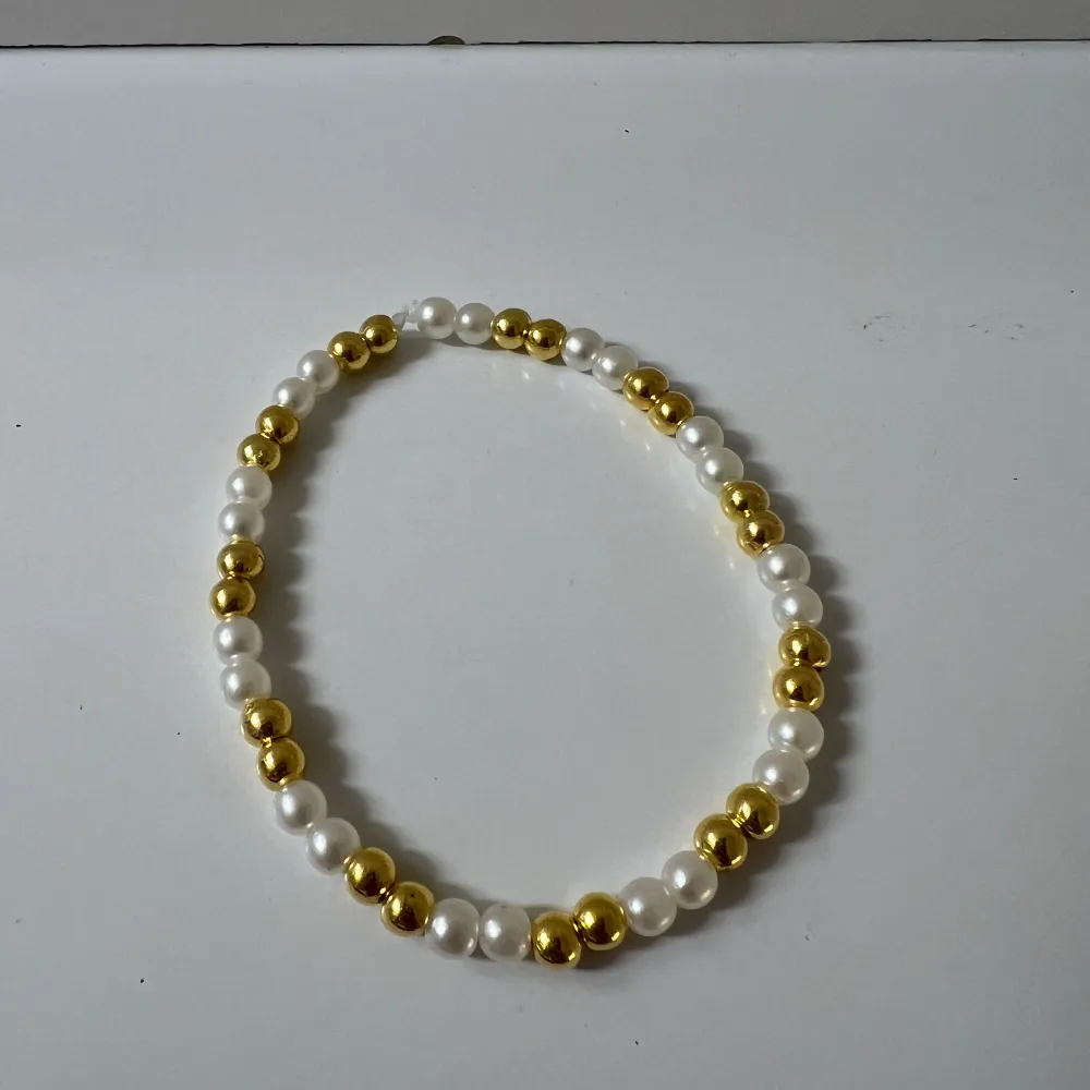 Helt nytt armband med vita och guldiga pärlor . Accessoarer.
