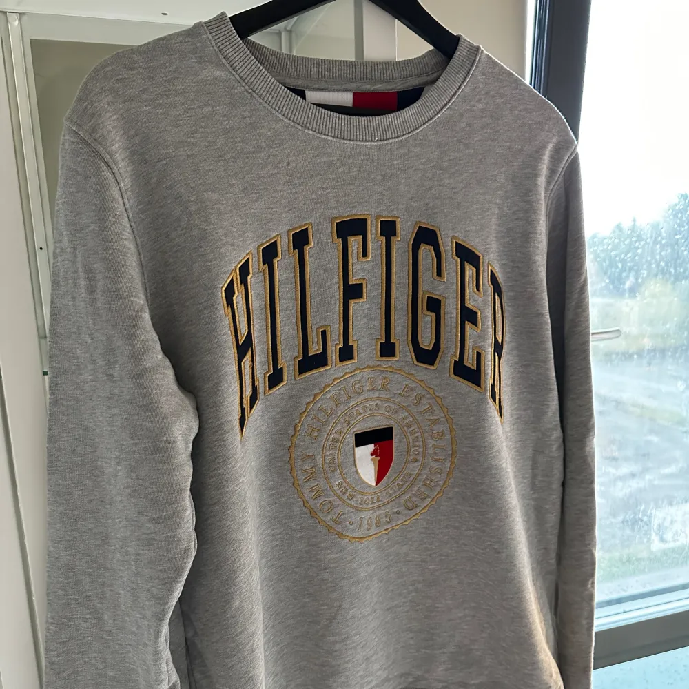 En grå Tommy hilfiger sweatshirt med tryck. Stl M med skön passform! 🩶 fin fint skick!. Tröjor & Koftor.