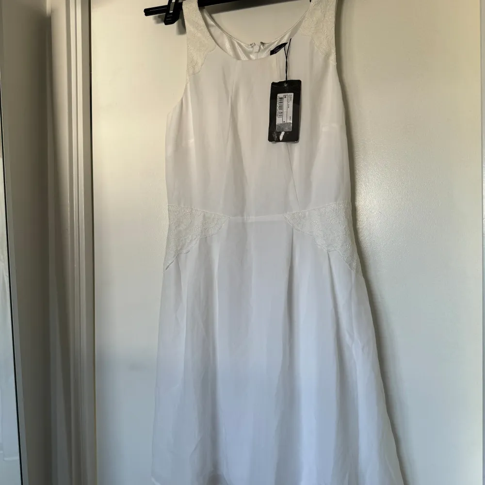 Oanvänd vit miniklänning med spetsdetaljer, prislapp är kvar! Perfekt till studenten eller till midsommar! En riktig sommardröm . Klänningar.